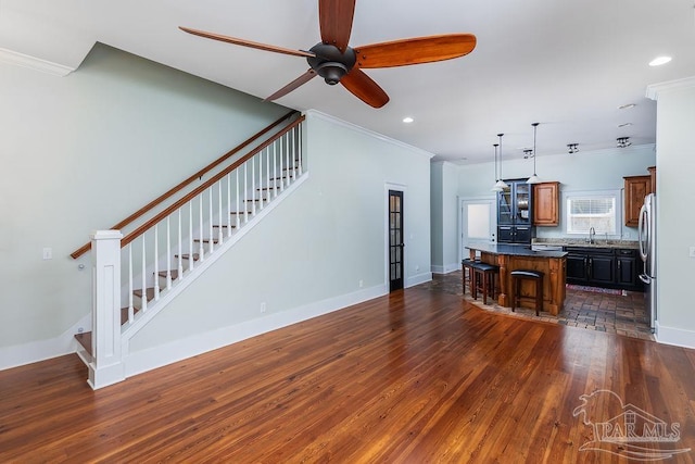 living room featuring stairway, ornamental molding, and dark wood-style flooring