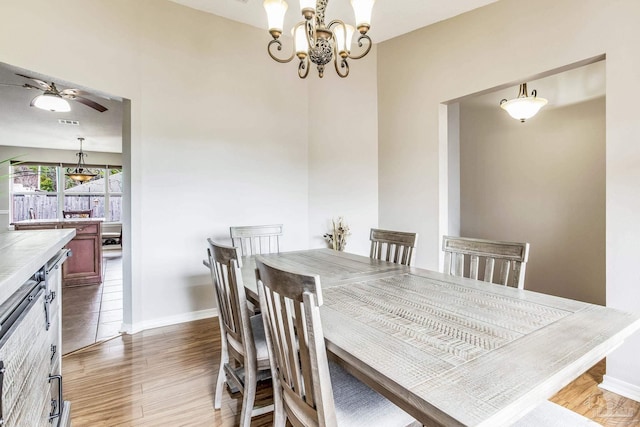 dining room featuring dark wood-type flooring and ceiling fan with notable chandelier