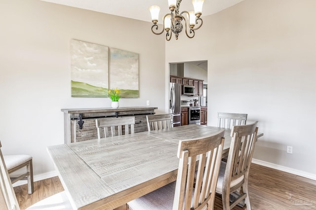 dining area with dark hardwood / wood-style floors and a notable chandelier