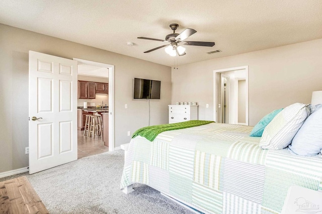 carpeted bedroom featuring a textured ceiling and ceiling fan