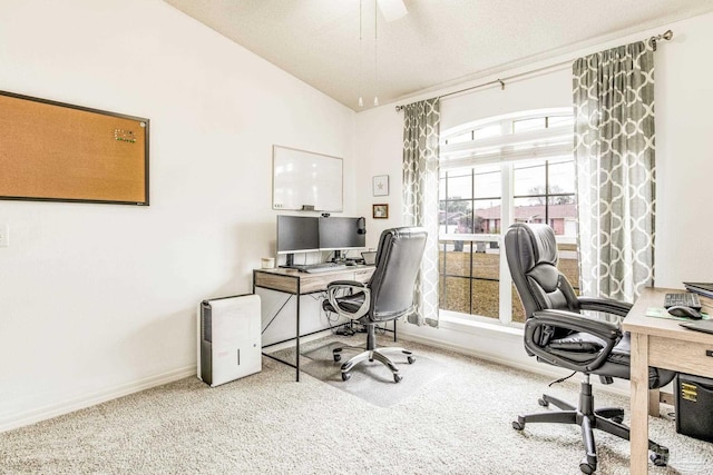 carpeted home office with vaulted ceiling