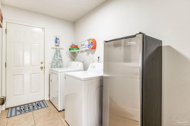 laundry room with light tile patterned flooring and washer and dryer