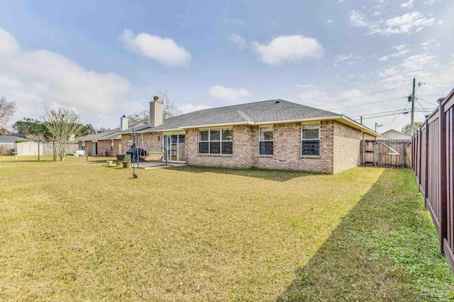 rear view of property featuring a patio and a lawn