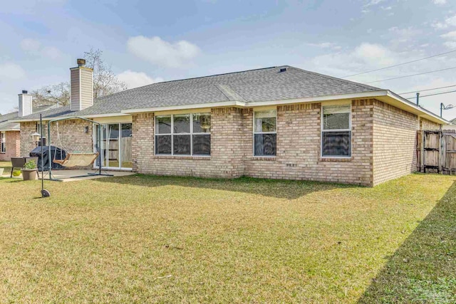 rear view of property with a lawn and a patio