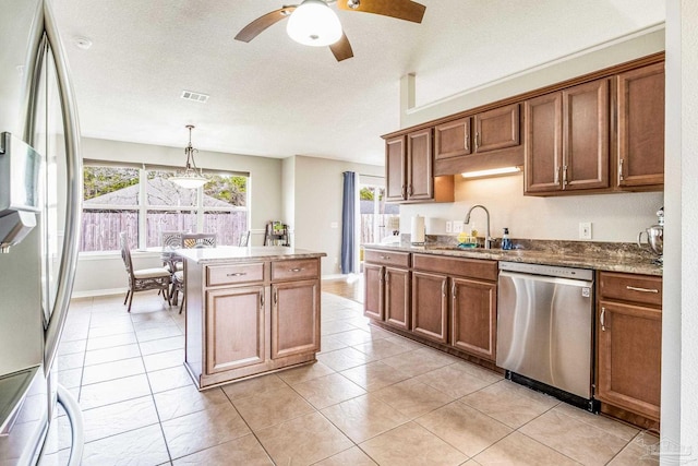 kitchen with sink, hanging light fixtures, a center island, light tile patterned floors, and stainless steel appliances