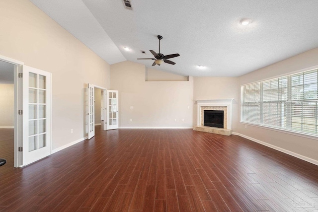 unfurnished living room featuring ceiling fan, french doors, a high end fireplace, dark hardwood / wood-style floors, and lofted ceiling