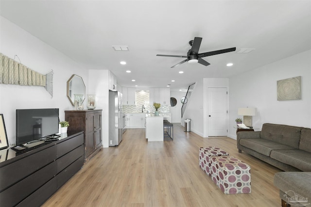 living room featuring ceiling fan and light wood-type flooring