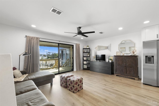 living room with ceiling fan and light hardwood / wood-style flooring