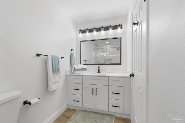 bathroom with vanity, hardwood / wood-style flooring, toilet, and walk in shower