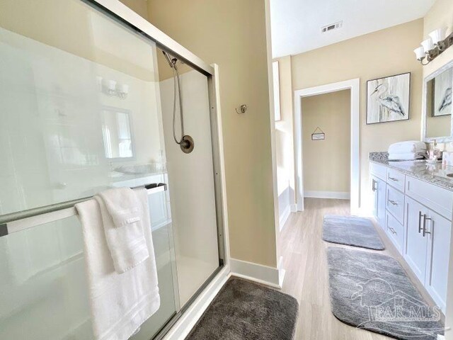 bathroom featuring hardwood / wood-style floors, vanity, and an enclosed shower