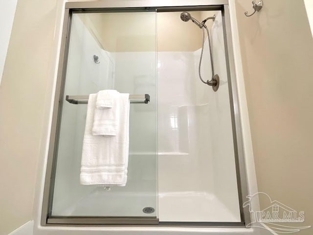 bathroom featuring a shower with shower door