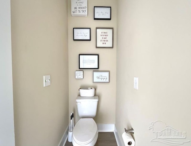 bathroom with hardwood / wood-style floors and toilet