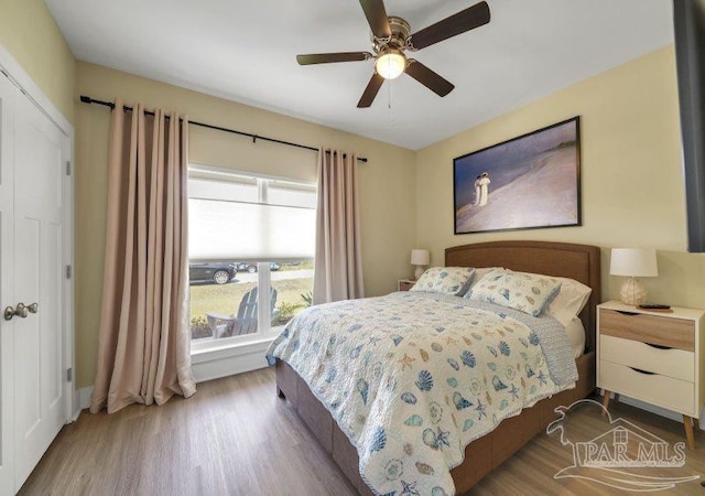 bedroom with ceiling fan, a closet, and hardwood / wood-style flooring