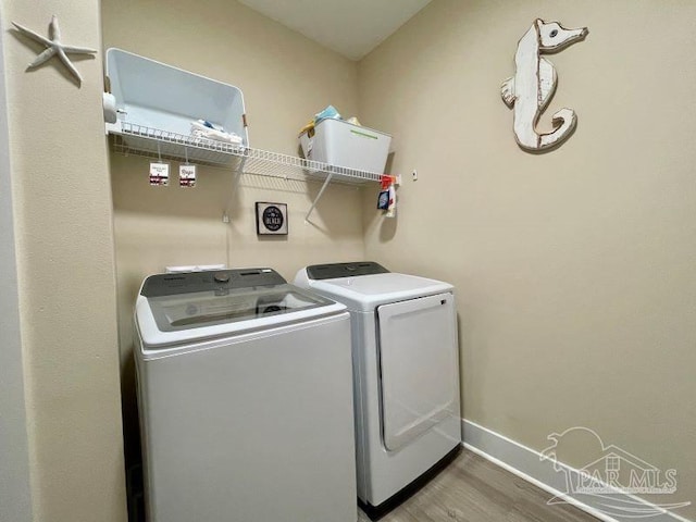 washroom with separate washer and dryer and hardwood / wood-style flooring