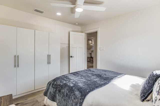 bedroom featuring ceiling fan, light wood-type flooring, and a closet