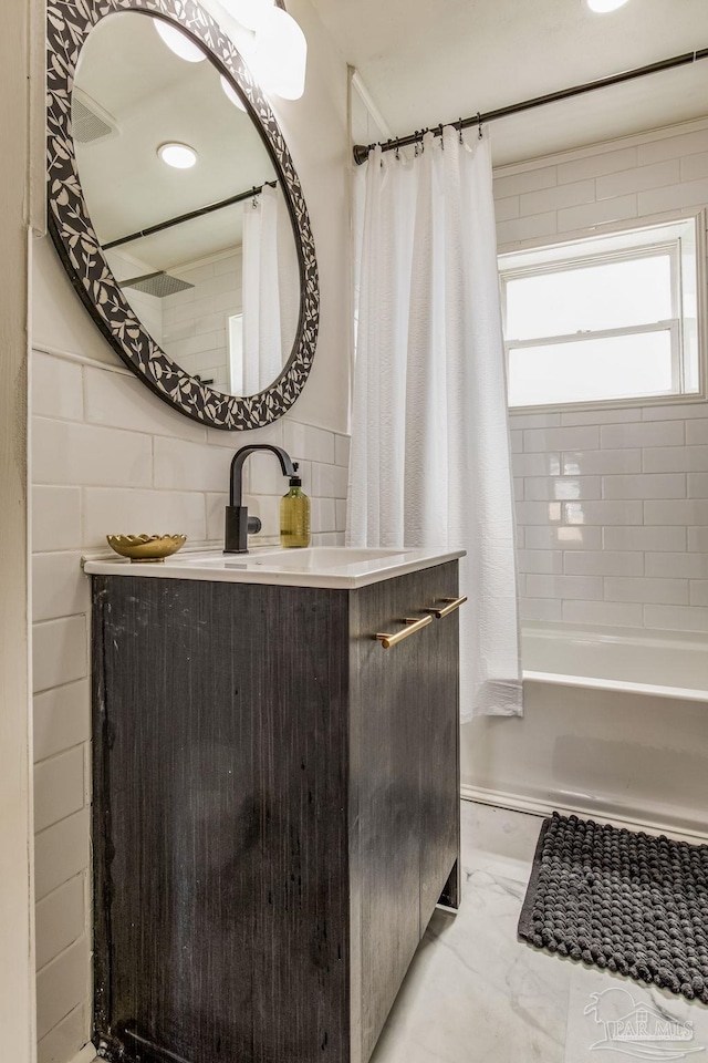 bathroom with vanity, tile walls, and shower / tub combo with curtain