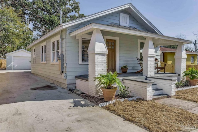 bungalow with a garage, an outdoor structure, and a porch