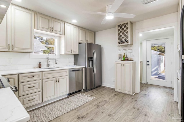 kitchen featuring sink, light hardwood / wood-style flooring, ceiling fan, stainless steel appliances, and tasteful backsplash