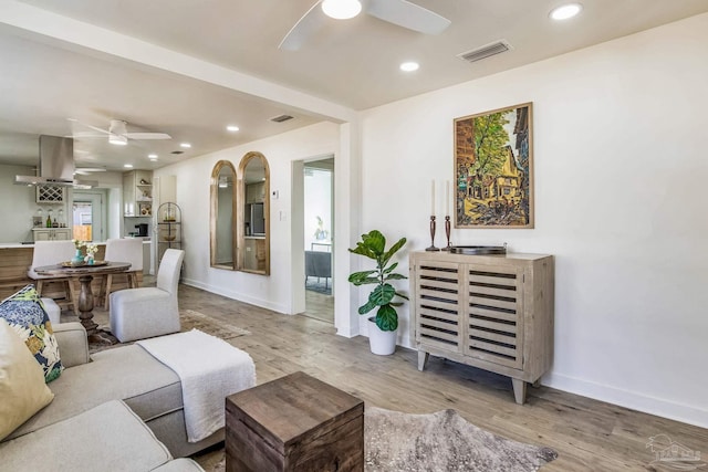 living room with ceiling fan and light hardwood / wood-style flooring