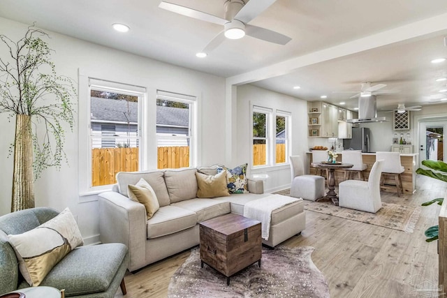 living room featuring light hardwood / wood-style flooring and ceiling fan