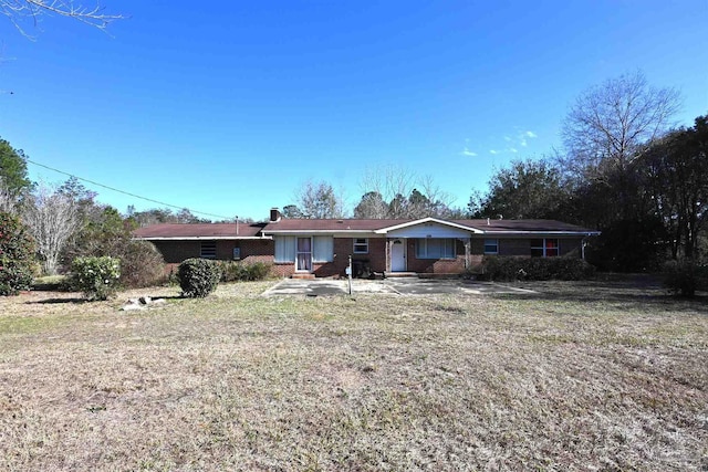 view of front of property with brick siding and a front yard