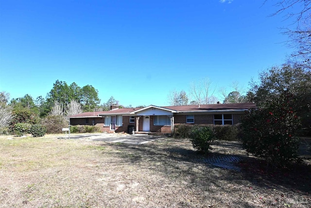 single story home featuring a chimney and brick siding