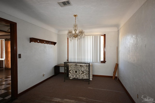 empty room featuring an inviting chandelier, baseboards, and visible vents