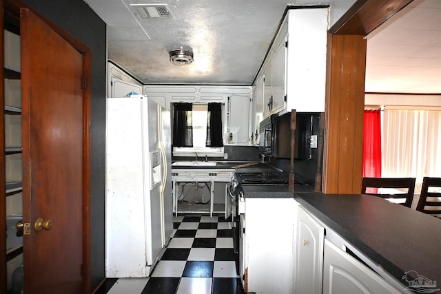 kitchen featuring black microwave, dark floors, white refrigerator with ice dispenser, visible vents, and white cabinetry