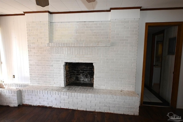 details with a brick fireplace, crown molding, and wood finished floors