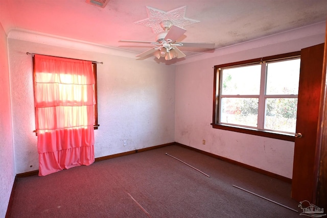 unfurnished room with carpet floors, visible vents, baseboards, and a ceiling fan