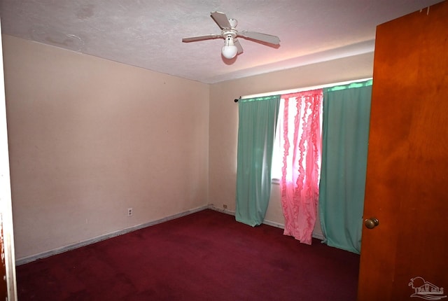 empty room featuring carpet flooring, ceiling fan, a textured ceiling, and baseboards