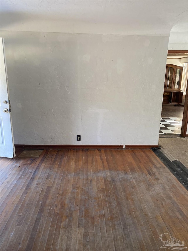 empty room featuring hardwood / wood-style floors and baseboards