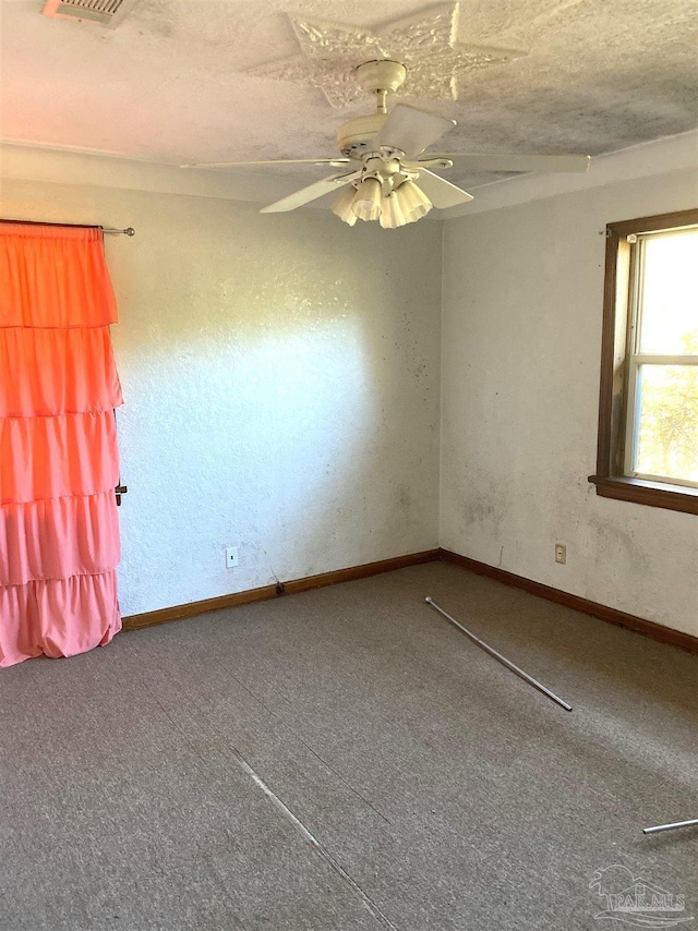 unfurnished room with ceiling fan, a textured ceiling, baseboards, and carpet flooring