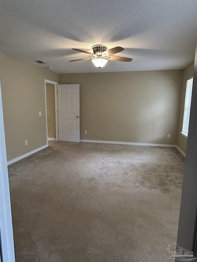 carpeted spare room with a textured ceiling and ceiling fan