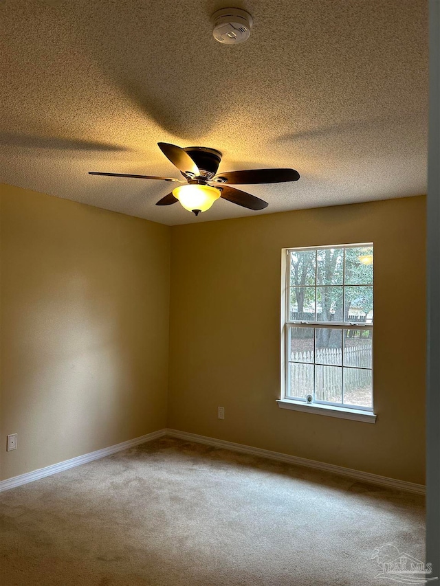 unfurnished room featuring carpet flooring, ceiling fan, and a textured ceiling