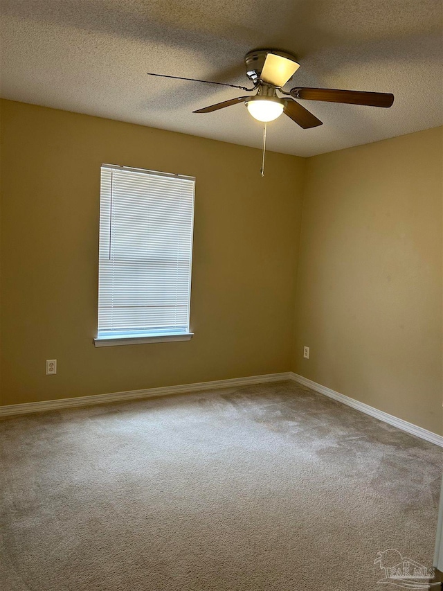 carpeted spare room with a textured ceiling and ceiling fan