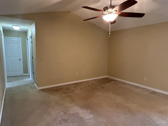 spare room featuring ceiling fan, light colored carpet, and vaulted ceiling