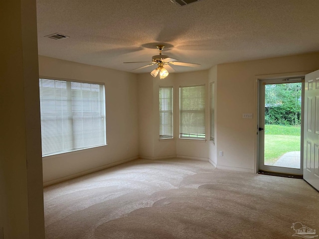 carpeted spare room featuring a textured ceiling and ceiling fan