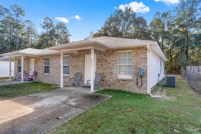 view of front of property featuring central AC unit, a patio area, and a front yard