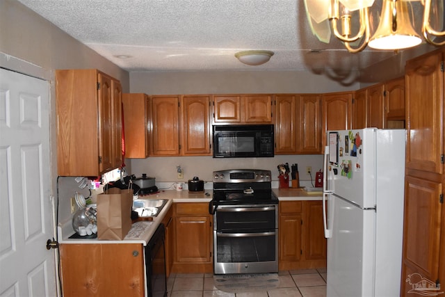 kitchen featuring an inviting chandelier, light tile patterned flooring, a textured ceiling, and black appliances