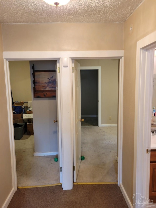 corridor featuring carpet and a textured ceiling