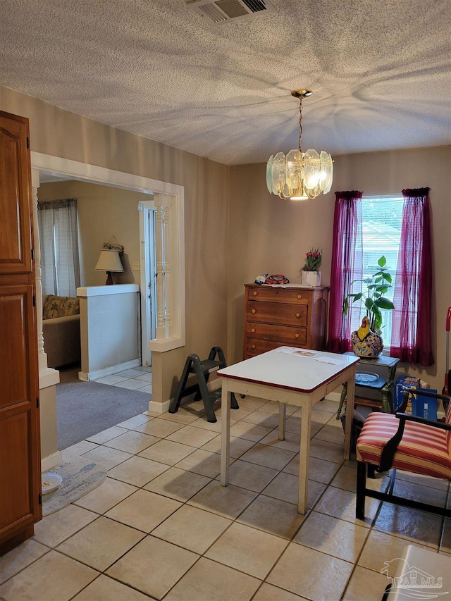 6017 Montgomery Ave, Pensacola, FL 32526 - dining space featuring a textured ceiling, light tile patterned flooring, a notable chandelier, and visible vents