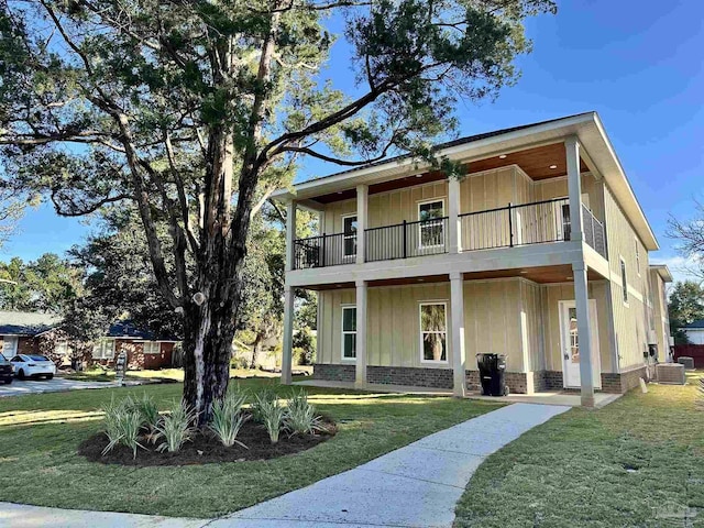 exterior space featuring a balcony, a yard, and central air condition unit