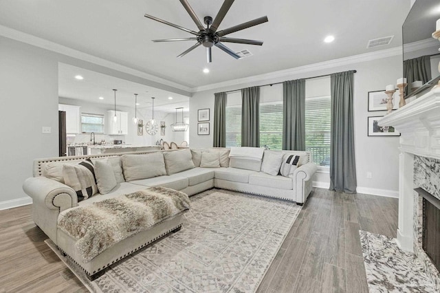 1567 Sawyers Ridge Cv, Cantonment, FL 32533 - living area with ceiling fan, a premium fireplace, light wood finished floors, crown molding, and recessed lighting