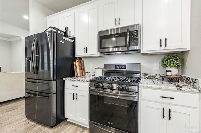 1567 Sawyers Ridge Cv, Cantonment, FL 32533 - kitchen featuring appliances with stainless steel finishes, light stone countertops, white cabinetry, light wood-style floors, and crown molding