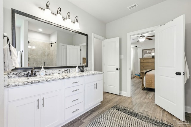 1567 Sawyers Ridge Cv, Cantonment, FL 32533 - ensuite bathroom featuring double vanity, a shower stall, ceiling fan, and wood finished floors