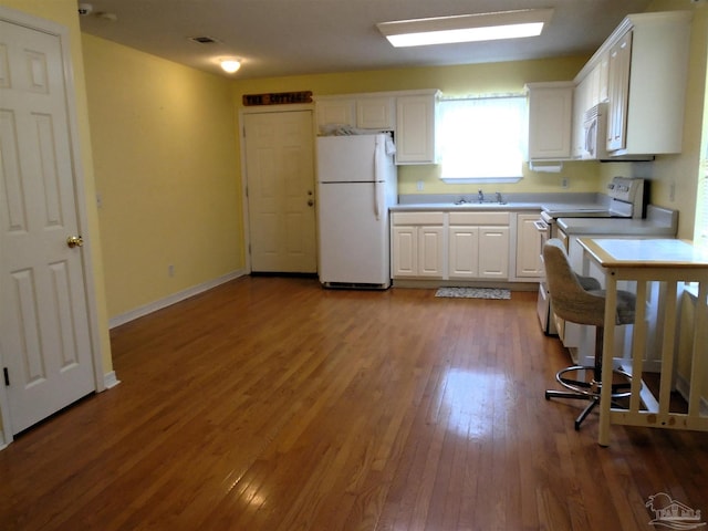 7067 Pine Blossom Rd, Milton, FL 32570 - kitchen featuring white appliances, white cabinets, hardwood / wood-style floors, and light countertops