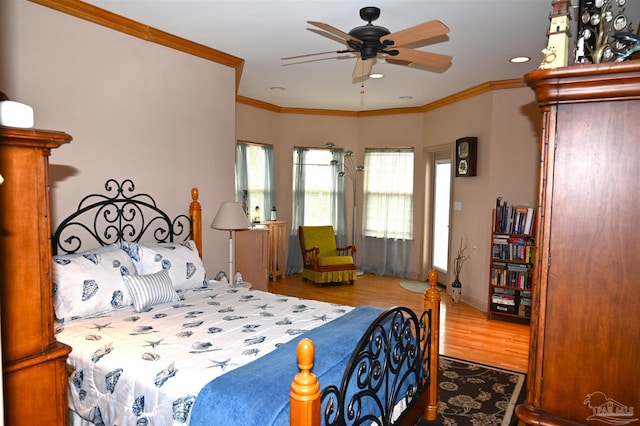 bedroom featuring hardwood / wood-style flooring, ornamental molding, and ceiling fan