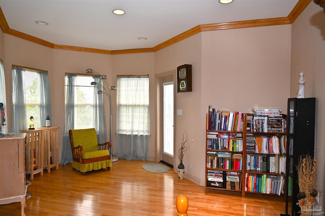 sitting room featuring crown molding and light hardwood / wood-style flooring