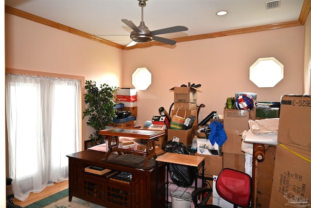 office space featuring crown molding, ceiling fan, wood-type flooring, and a healthy amount of sunlight